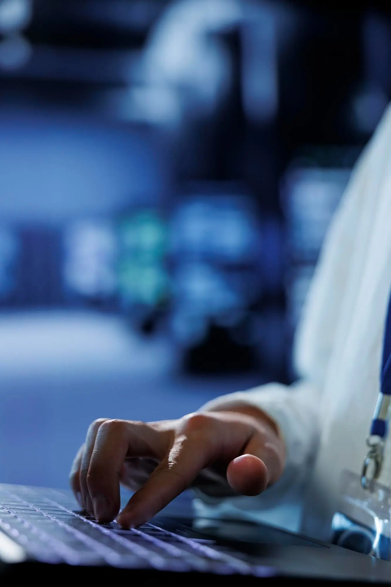 Крупный план: компетентный администратор в дата-центре использует ноутбук, чтобы предотвратить перегрузку системы в периоды пикового трафика; опытный эксперт в серверном узле обеспечивает достаточную пропускную способность сети для бесперебойной работы.